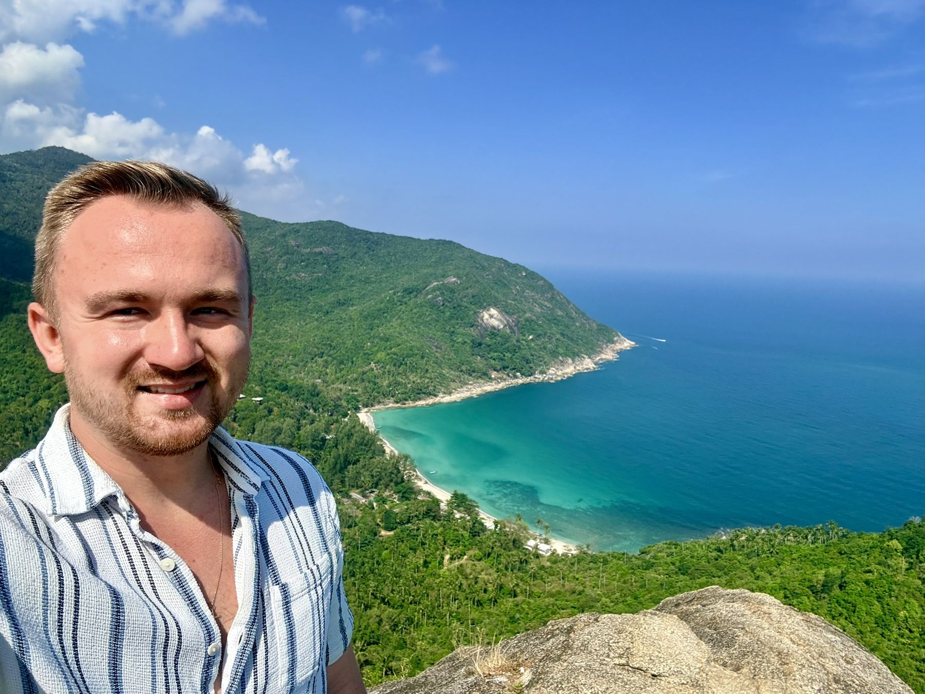 Michael auf einem Aussichtspunkt über einer Bucht mit türkisem Meer in Thailand